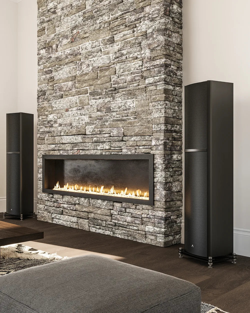 Black tower speaker beside a stone fireplace