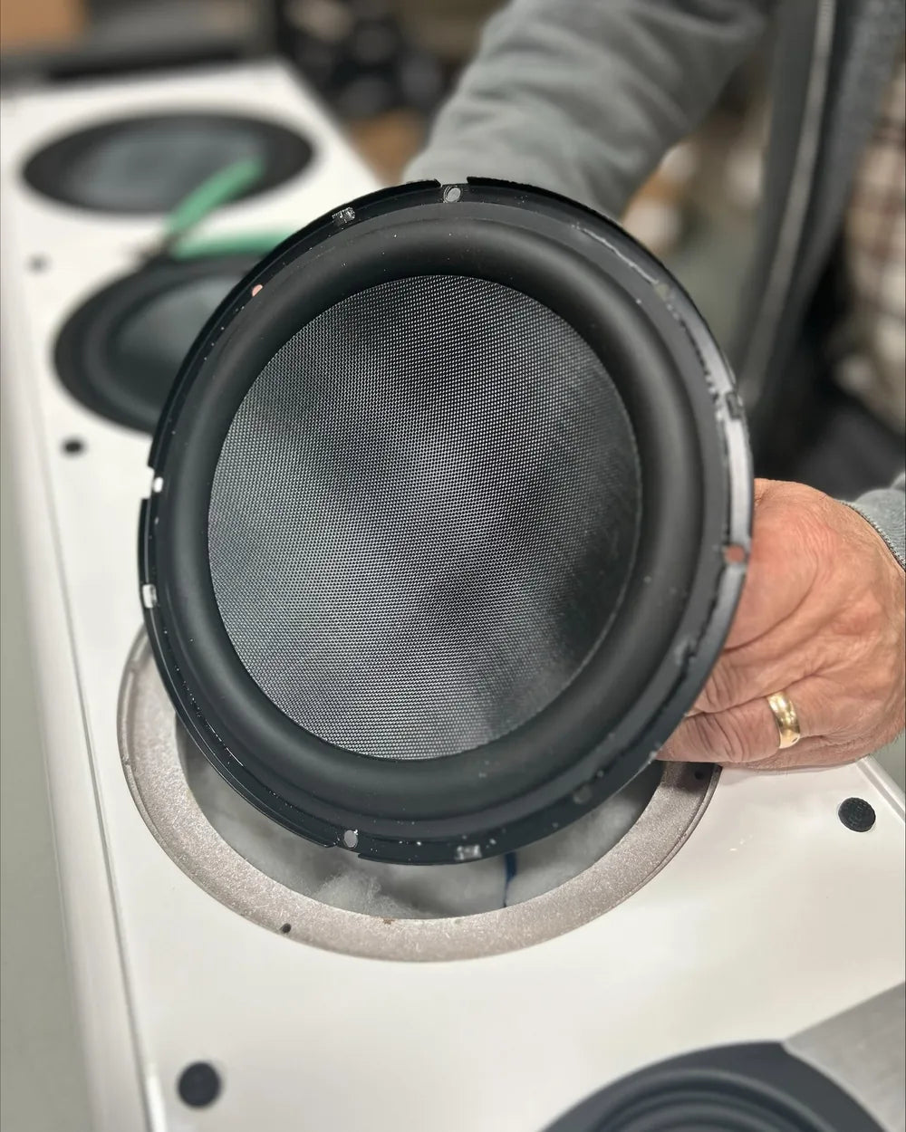 A speaker driver being handled at a workbench